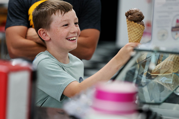 kid holding an ice cream smiling
